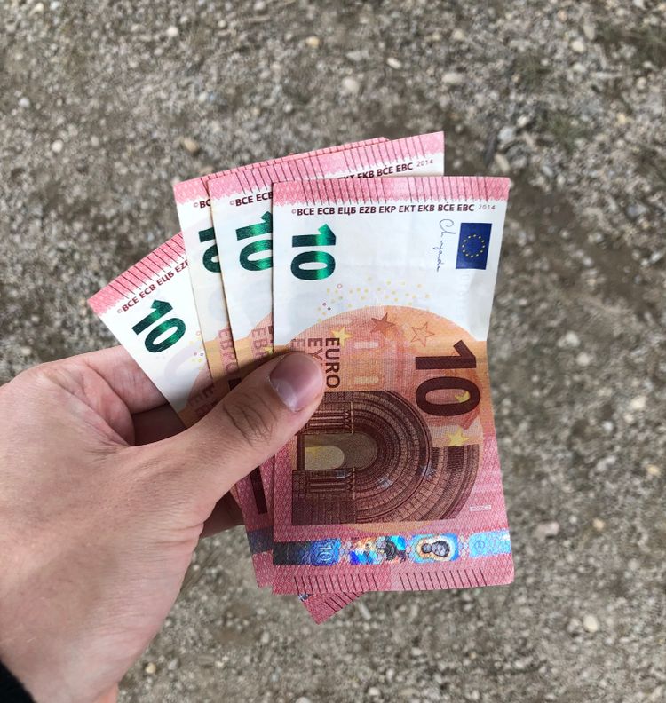 Vier Zehn-Euro-Scheine in einer Hand. 