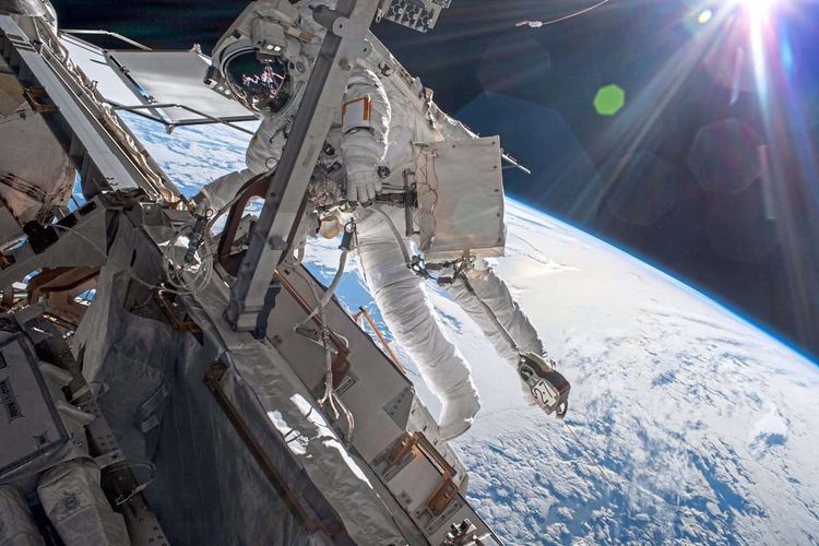 Esa-Astronaut Matthias Maurer bei einem Außeneinsatz an der Internationalen Raumstation ISS: Er arbeitet an einem Modul, im Hintergrund die Erde.