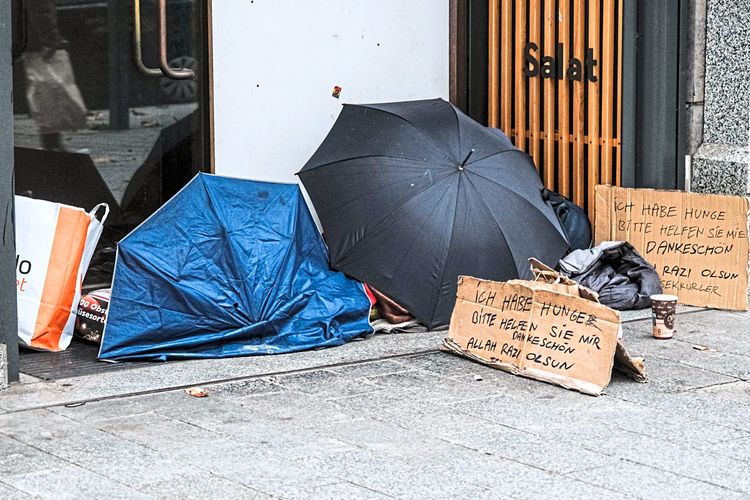 Schlafender obdachloser Mensch vor einem Geschäft.