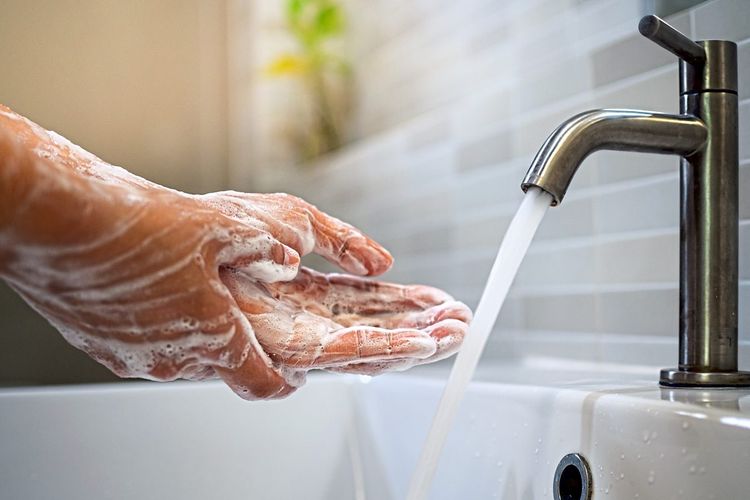 Hände mit Seife in einem Waschbecken