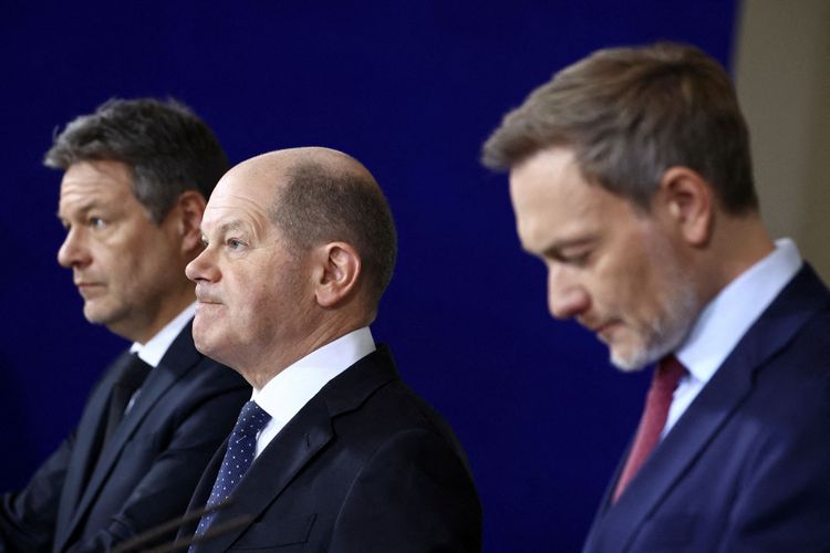 Die drei Politiker bei einer Pressekonferenz, nach links blickend