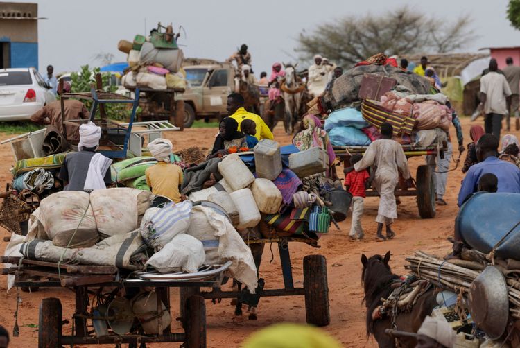 Aus dem Sudan flüchtende Menschen mit Karren, auf denen ihr Hab und Gut liegt, treffen im Tschad ein.