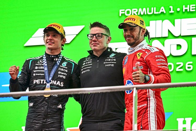 Zwei Rennfahrer und ein Ingenieur stehen auf dem Podium nach dem Formel-1-Grand-Prix von China am 15. März 2026 in Shanghai. Links trägt ein Fahrer einen schwarzen Rennanzug von Mercedes, rechts trägt ein Fahrer einen roten Rennanzug von Ferrari. In der Mitte steht ein Mann in schwarzer Teamkleidung von Mercedes. Alle posieren vor einem grünen Hintergrund mit der Aufschrift „Formula 1 Heineken“.