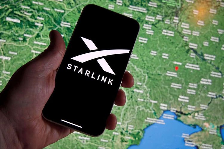 Ein Starlink-Logo ist auf einem Smartphone zu sehen, im Hintergrund eine Karte der Ukraine.
