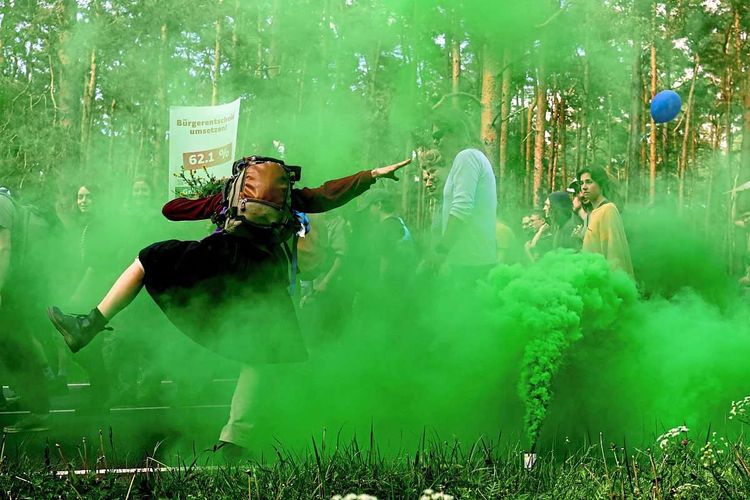 Grüner Rauch umgibt Protestanten.