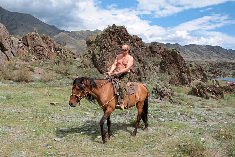 Putin reitet auf einem Pferd in den Bergen