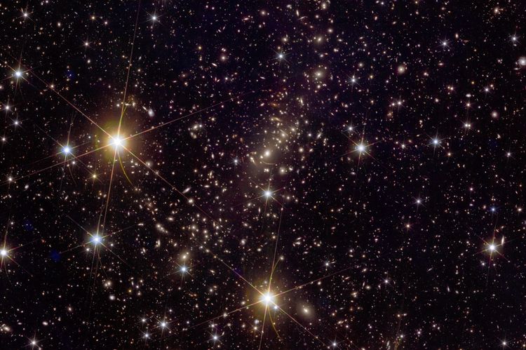 Ein Bild voller Sterne und Galaxien, von denen manche seltsam langgezogen sind.