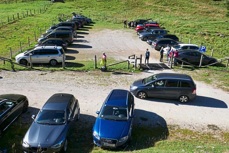 Ein Parklplatz am Berg, komplett voller Autos.