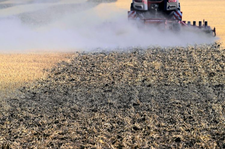 Ein Traktor lockert einen trockenen, harten Boden nach der Getreideernte auf. Der Boden ist staubig und trocken, mit aufsteigendem Staub. Aufgenommen in Niederösterreich am 3. August 2026.
