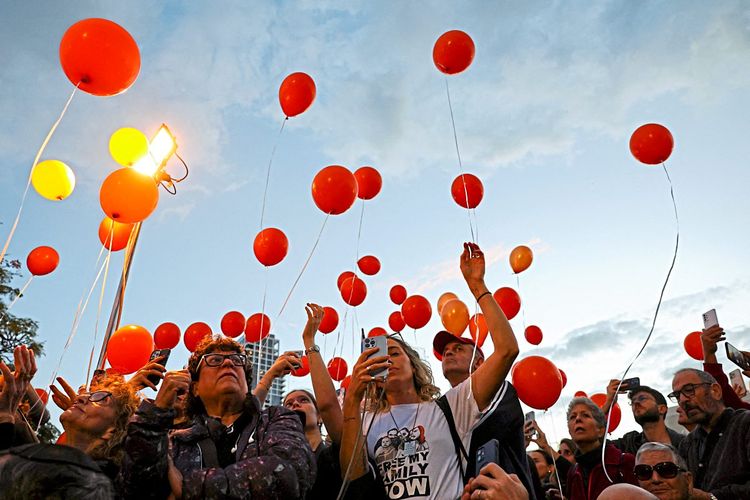 Menschen lassen rote Ballons in den Himmel steigen 