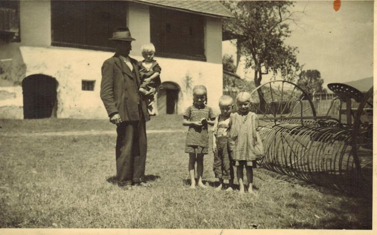 Familie steht vor einem Haus, altes Foto
