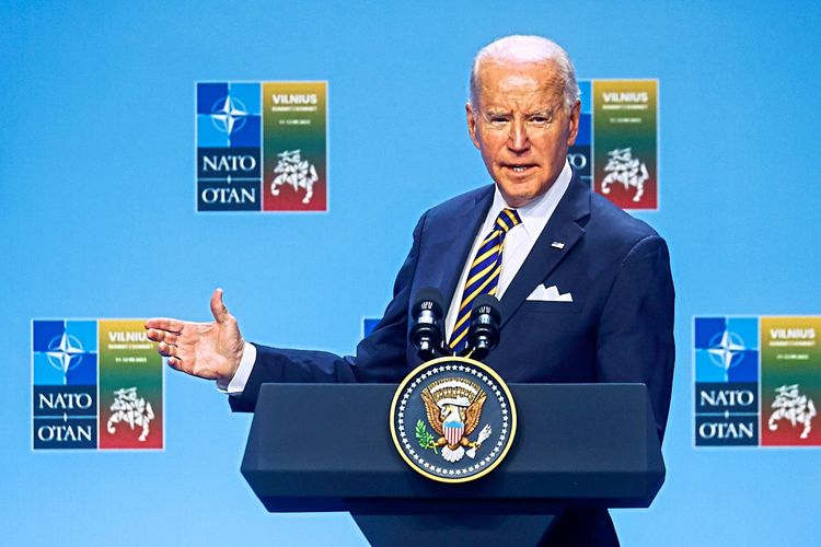 Joe Biden vor Nato-Logos an einem Rednerpult.