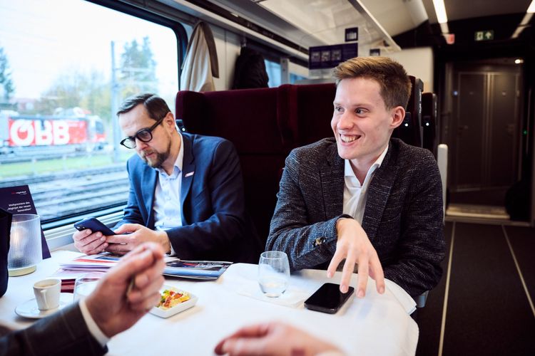 Zwei Männer an einem Tisch im Zug.