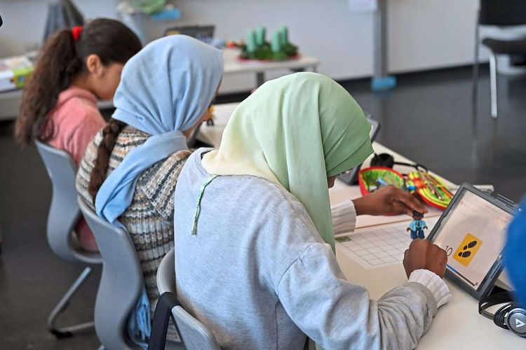 Schülerinnen aus Syrien und Afghanistan lernen am Tablet