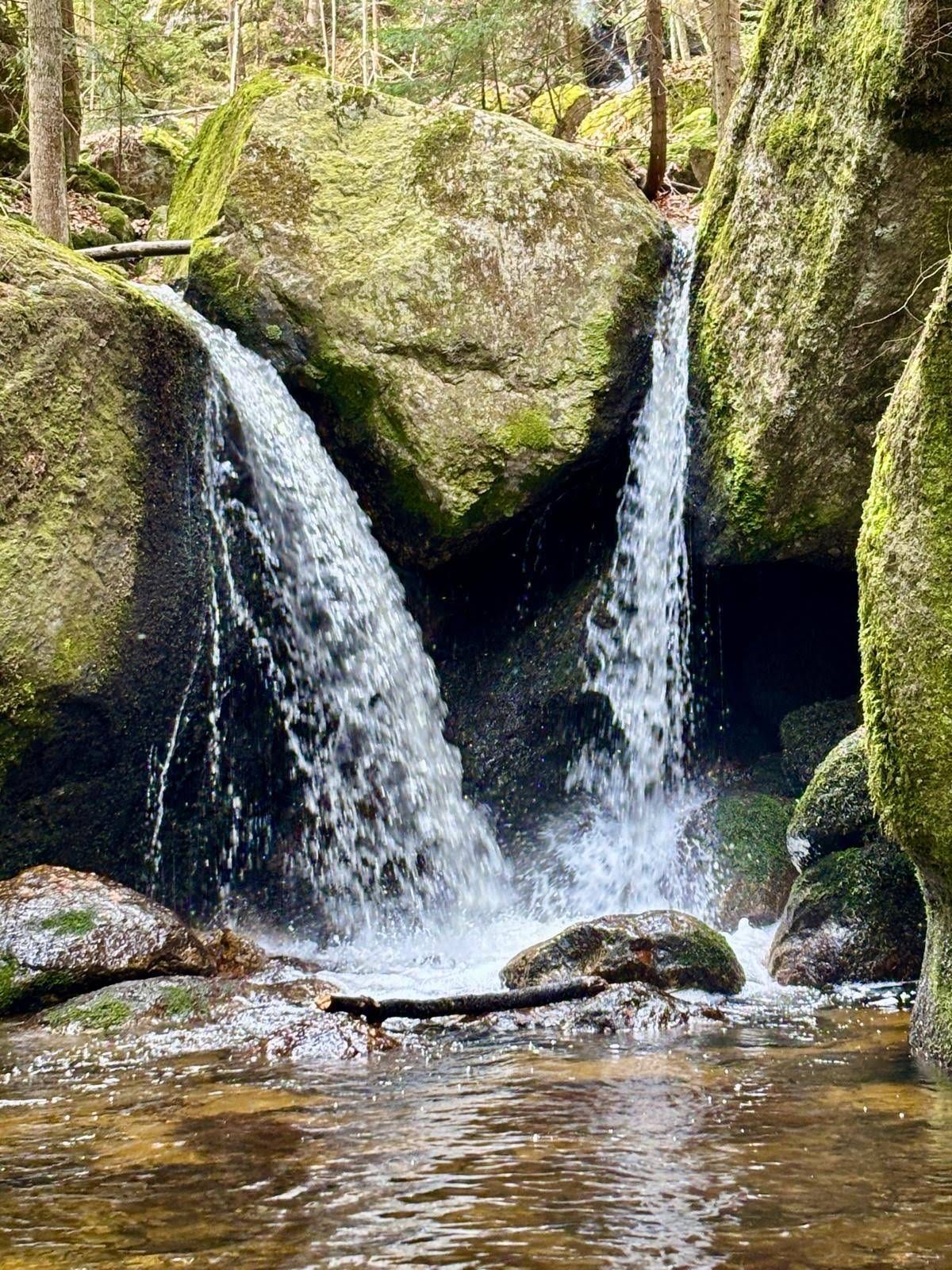 Wasser schießt aus Felsen hervor und bildet einen Teich