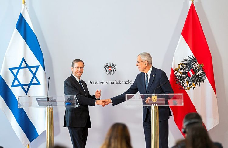 Herzog gibt Van der Bellen die Hand. Im Hintergrund sind die israelische und österreichische Flagge zu sehen.