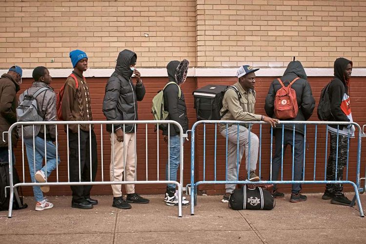 Menschen stehen in einer Schlange vor einer Unterkunft in New York.
