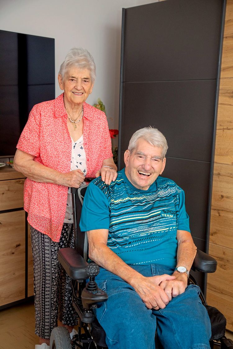 Margarete und Manfred Denner lachend in ihrer Wohnung.