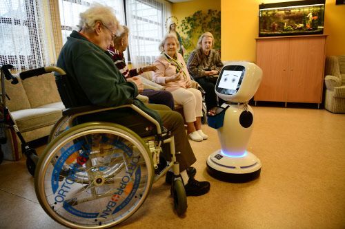 Alte Damen bekommen Hilfe von einem Pflegeroboter