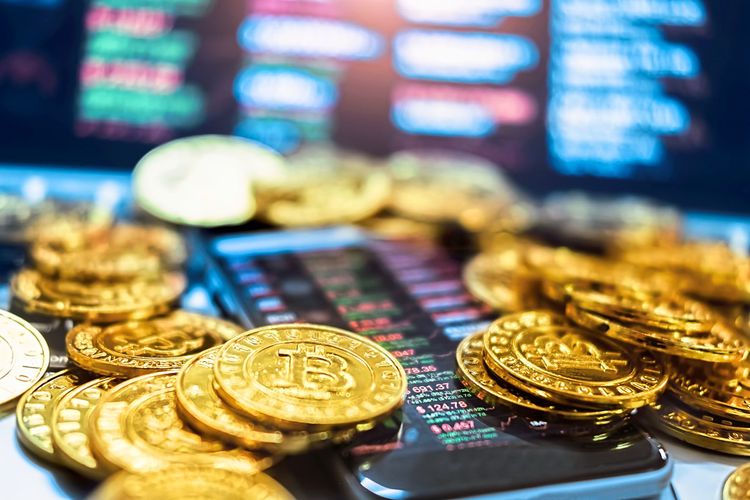Das Bild zeigt symbolische Bitcoinmünzen rund um ein Smartphone, das Kryptowährungskurse anzeigt.