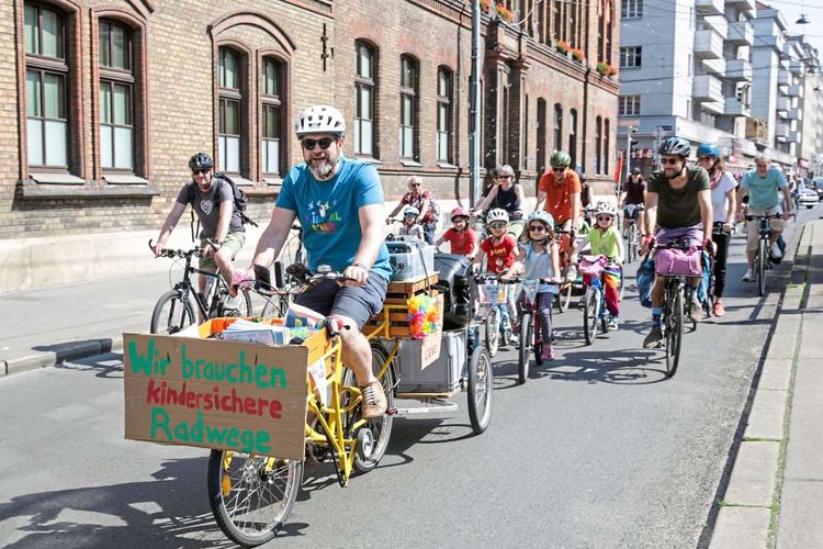 Erwachsene und Kinder fahren mit ihren Rädern durch Wien.