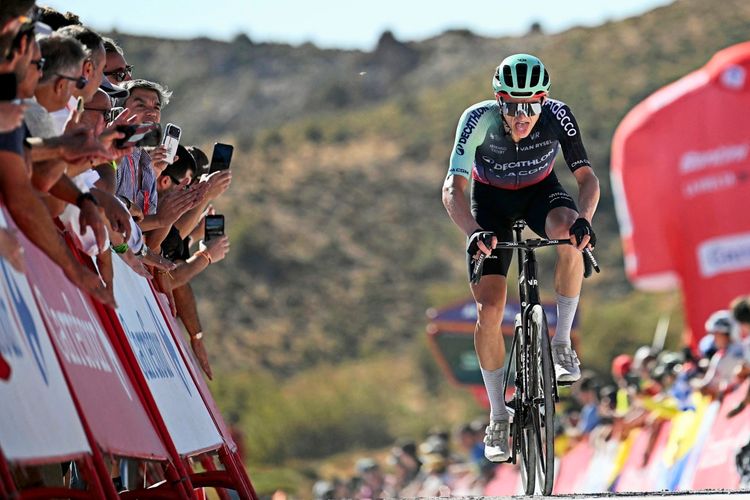 Ein Radfahrer im Trikot des Teams Decathlon CMA CGM überquert die Ziellinie während der 20. Etappe der Vuelta a España 2026, einer 186,8 km langen Strecke zwischen La Calahorra und Collado del Alguacil. Zuschauer stehen hinter Absperrungen und jubeln.